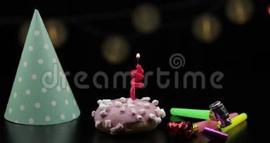 派对。 粉红色的甜甜圈和红色的节日蜡烛在上面。 <strong>金色纸</strong>屑掉落
